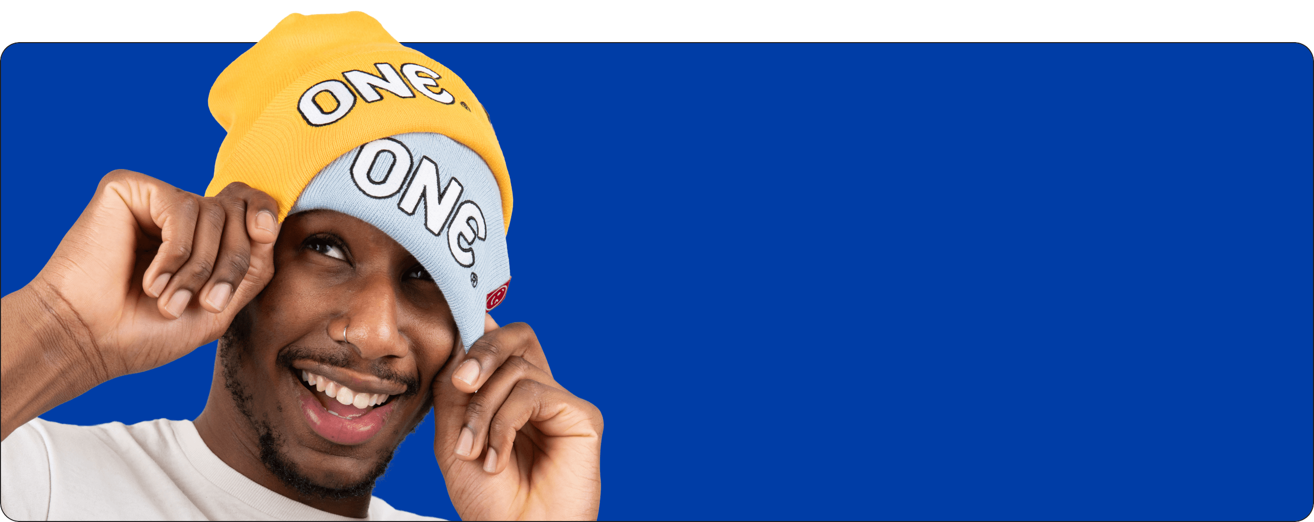 Man wearing a yellow and white beanie with 'ONE' text on a blue background