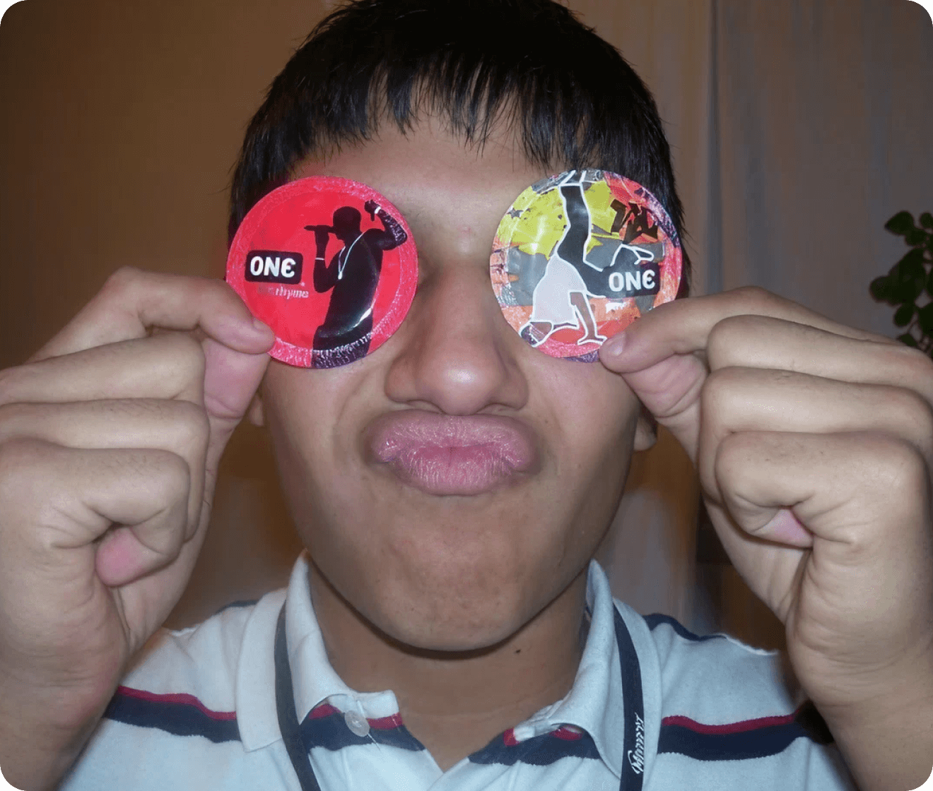 Person holding colorful circular objects with 'ONE' branding in front of their eyes.